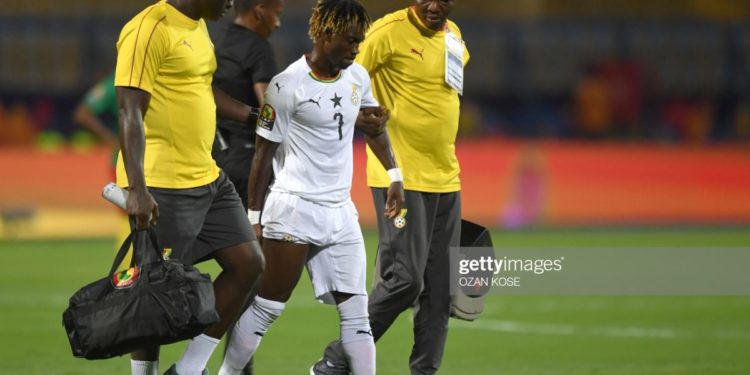 Ghana's midfielder Christian Atsu (C) is escorted off the pitch for treatment during the 2019 Africa Cup of Nations (CAN) Group F football match between Cameroon and Ghana at the Ismailia Stadium on June 29, 2019. (Photo by OZAN KOSE / AFP)        (Photo credit should read OZAN KOSE/AFP/Getty Images)