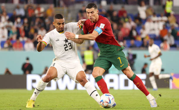DOHA, QATAR - NOVEMBER 24: Cristiano Ronaldo of Portugal and Alexander Djiku of Ghana compete for the ball during the FIFA World Cup Qatar 2022 Group H match between Portugal and Ghana at Stadium 974 on November 24, 2022 in Doha, Qatar. (Photo by Sarah Stier - FIFA/FIFA via Getty Images)