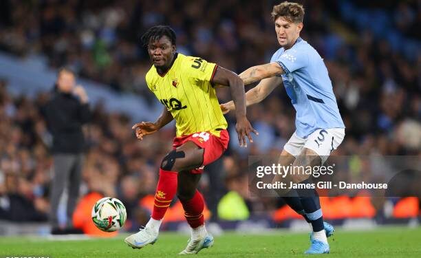MANCHESTER, ENGLAND - SEPTEMBER 24: Kwadwo Baah of Watford battles for possession with John Stones of Manchester City during the Carabao Cup Third Round match between Manchester City and Watford  at Etihad Stadium on September 24, 2024 in Manchester, England. (Photo by James Gill - Danehouse/Getty Images)