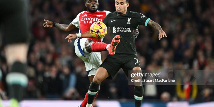 LONDON, ENGLAND - OCTOBER 27: Luis Diaz of Liverpool is challenged by Thomas Partey of Arsenal during the Premier League match between Arsenal FC and Liverpool FC at Emirates Stadium on October 27, 2024 in London, England. (Photo by Stuart MacFarlane/Arsenal FC via Getty Images)